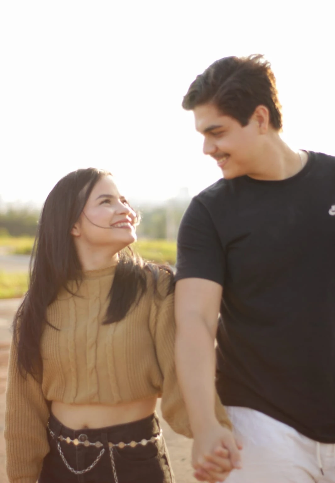 Esther e Felipe, fundadores da FE Studio Co., de mãos dadas ao ar livre